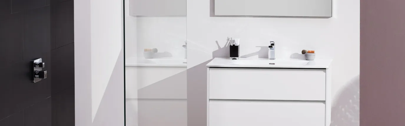 Ein modernes Badezimmer mit minimalistischer Gestaltung zeigt einen weißen Waschtisch mit zwei Schubladen und einem schlichten Spiegel darüber.