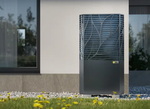 Paradigma-Wärmepumpe WP Aero Calima steht im Garten vor einem Haus