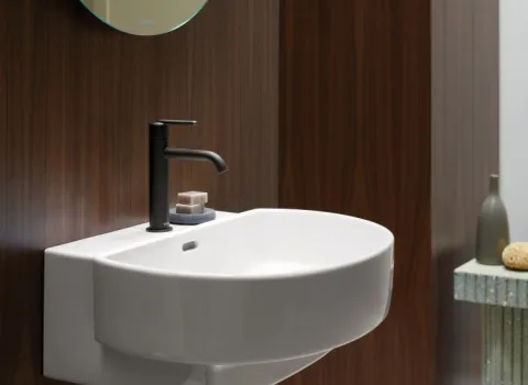 Wandhaengendes Waschbecken der Serie Balcoon von Duravit vor einer dunklen Holzwand.