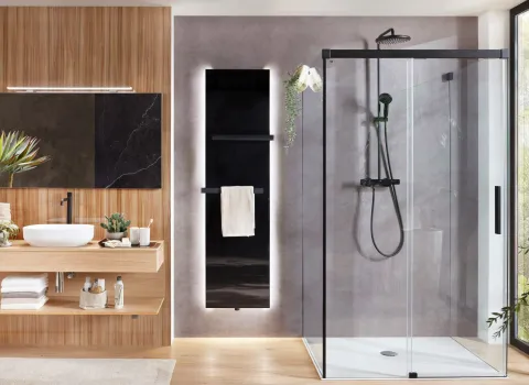 Modernes Badezimmer mit Designheizkörper Plawa Purline Glas von BEMM in schwarzer Farbe mit weißer LED-Beleuchtung.